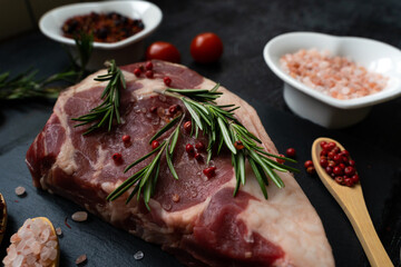 Cooking ribeye steak beef fillet. Close-up meat with spices, salt and rosemary. An appetizing piece of meat. Holiday preparations