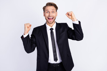 Photo of young man happy positive smile rejoice win victory lucky fists hands isolated over grey color background