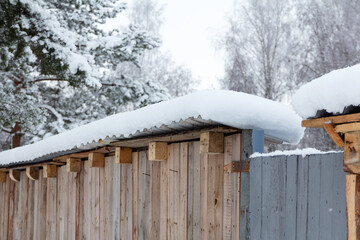 Snow covered wooden fence surface in winter forest