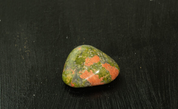 Unakite pebbles green epidote natural mineral stone from Republic of South Africa RSA. Mineralogy, geology, magic of stones, semi-precious stones and samples of minerals. Close-up macro photo.