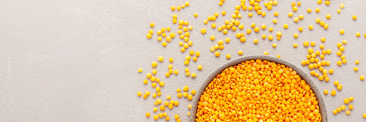 Legumes in bowl and scattered in the background, lentils in a plate banner, top view, copy space