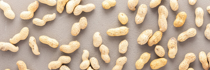 Legumes are scattered in the background, natural banner of peanuts, top view