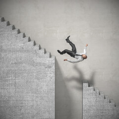 businessman climbs the stairs and falls in a dangerous spot.