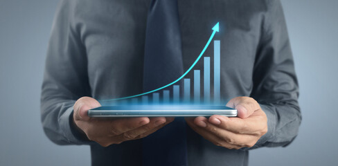 Businessman plan graph growth increase of chart positive indicators in his business,tablet in hand