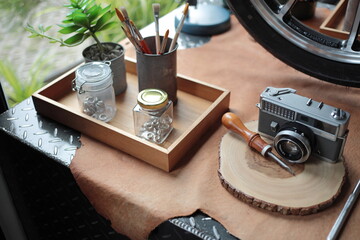 A classic camera in a cafe at Phuket old town. I is put on a weed tray. There are some paint-brush on it's side.