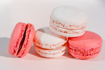 Pink and white macarons on light wooden background. French Pastel Macaroons. Blurred focus