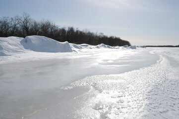 Fototapeta na wymiar Reflection of sunlight on a frozen river.