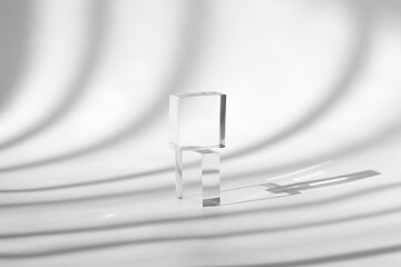 Minimal cosmetic background. Pedestal display glass cube, block platform, transparent geometric stand for cosmetics, mockup scene with sunlight and shadow. Acrylic podium for product presentation.
