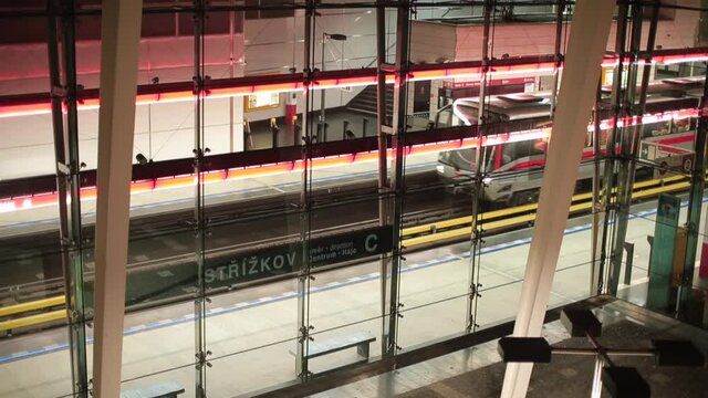 The movement of subway trains at the station. Glass enclosure protects against noise and wind. Public transport operation.