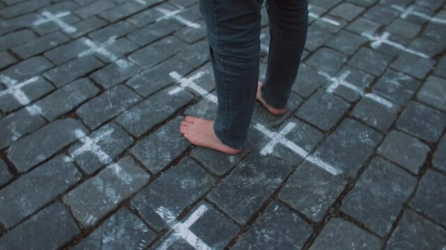 Pilgrim's bare feet on stone floor. Crosses drawn. Symbolising the right path. A place of purification, an invisible connection. Circular movement of the camera.