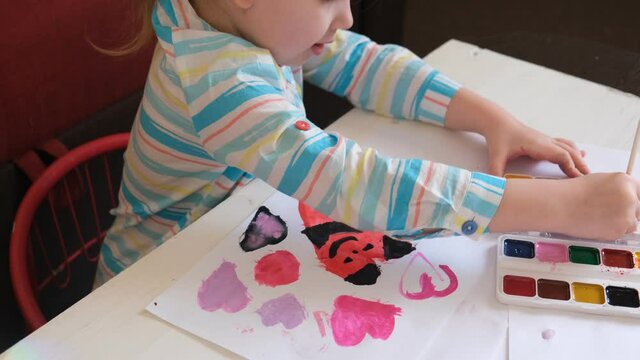 little girl drawing with watercolors, Kids art. Crafts concept. How to make a greeting card, Creating handmade gifts for Mothers Day or kids birthday