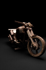 Plakat Wooden toy motorcycle on a black background a close up