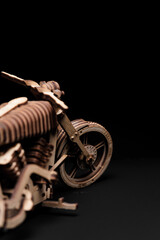 Wooden toy-motorcycle designer on a black background