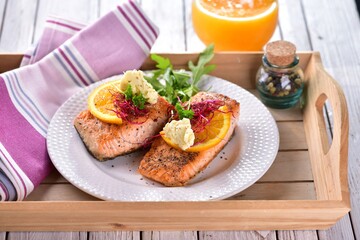 Grilled salmon fish with orange butter and rocket salad