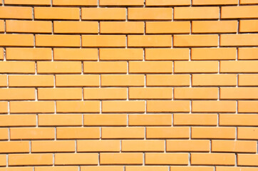 Obraz premium Close-up orange brick wall with copy space. Grunge brick wall background. Terracotta brick wall for texture. Decorative brick wall surface.