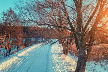 Country road covered with snow in the winter evening. View from above