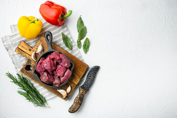 Raw meat diced for stew, on white stone  surface, top view flat lay, with copy space for text
