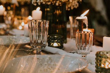 Wedding table setting with glasses, candles and flowers