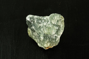 Prehnite green natural mineral stone from Republic of South Africa RSA on black background. Mineralogy, geology, magic of stones, semi-precious stones and samples of minerals. Close-up macro photo.