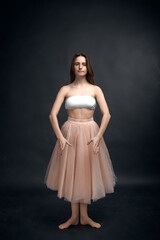 Obraz premium Young girl in white top and peach skirt dancing