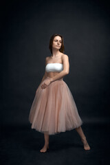 Fototapeta premium Young girl in white top and peach skirt dancing