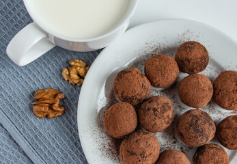 truffles with cocoa, coconut and sesame with chocolate and marshmallows and a cup of fresh milk, delicious dessert