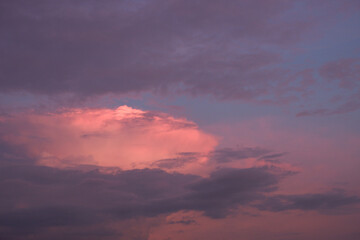 The sky at sunset before bad weather. Low red sunlight illuminates thunderclouds.