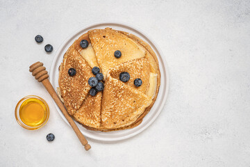 Homemade thin pancakes. Traditional Russian or Ukrainian homemade fried crepes. Light stone background