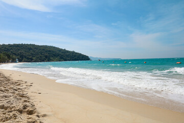 the tropical sandy beach with blue wave and clear sky in summer time