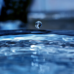 A crystal drop of water falls on the surface of the water surface