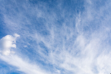 White cirrus clouds against blue sky on morning. Light, airy, white, cumulonimbus clouds in bright blue sky.