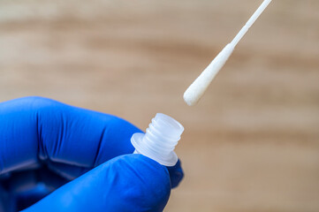 Abstrichtupfer wird nach nasalem Abstrich in ein Röhrchen mit Extraktionsflüssigkeit gesteckt