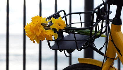Yellow bicycle with basket of flowers in the street