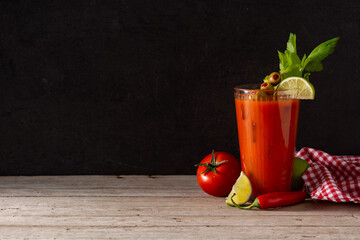 Bloody Mary cocktail in glass on rustic wooden table. Copy space