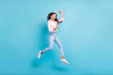 Fototapeta na wymiar Full size photo of young happy crazy smiling ecstatic girl jumping in victory say yes isolated on blue color background