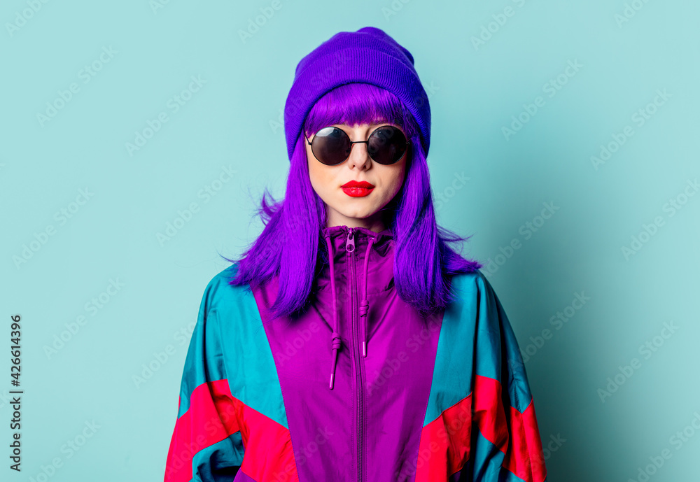 Poster stylish white girl with purple hair, 80s tracksuit and sunglasses on blue background