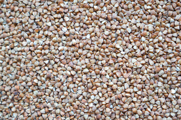 Dry buckwheat background, buckwheat close up. Roasted buckwheat. Brown cereals. Healthy buckwheat texture
