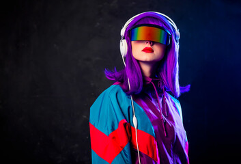 Stylish girl in cyber punk glasses and 80s tracksuit with headphones on dark background