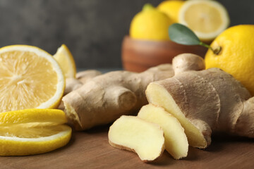 Cut ginger and lemon on wooden board, closeup