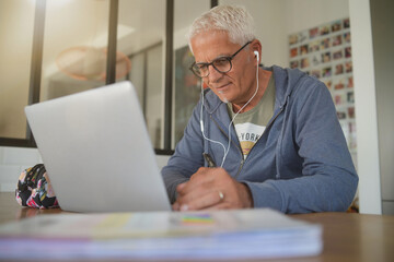 50 year old man working at home on his laptop