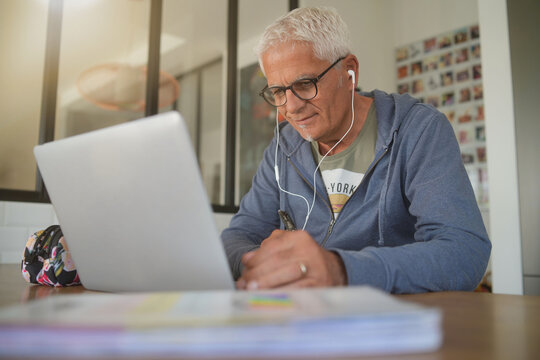 50 Year Old Man Working At Home On His Laptop