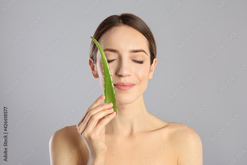 Sticker Young woman with aloe leaf on light grey background