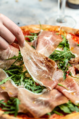 italian pizza with prosciutto parma ham, arugula and parmesan. Italian traditional food. Food recipe background. Close up