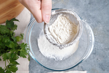 Flour is sieved with a metal sieveм