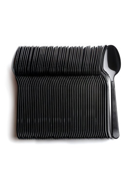 Packaging of black plastic disposable tablespoons. Disposable tableware.  Top view on white background.