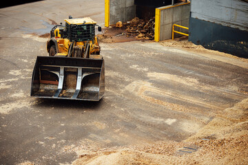 top view of the excavator at the factory. heavy industrial machinery moves around the territory of the enterprise. empty iron bucket of tractor