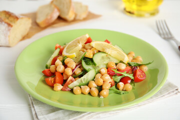 Delicious fresh chickpea salad on white wooden table