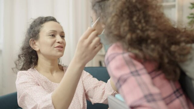 Caring Mom Putting Medical Mask On Little Daughter Before Classes, Health Care