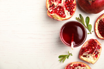 Glass of pomegranate juice and fresh fruits on white wooden table, flat lay. Space for text