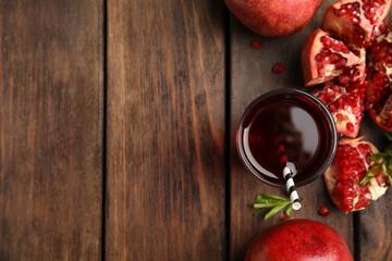 Pomegranate juice and fresh fruits on wooden table, flat lay. Space for text